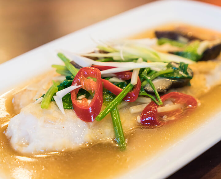 poisson blanc avec sauce beurre fondu et des légumes