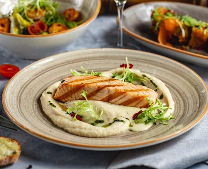 saumon grillé sur purée de pommes de terre avec sauces aux herbes